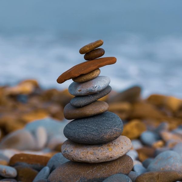 A stack of balanced stones on a beach, symbolizing inner peace and stability.